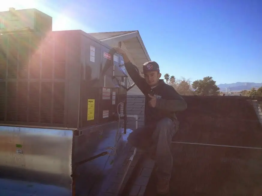 HVAC technician performing HVAC Inspection on a rooftop unit in Merced